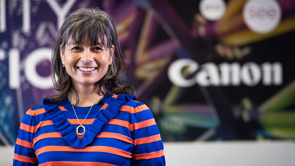 A woman is standing and smiling.