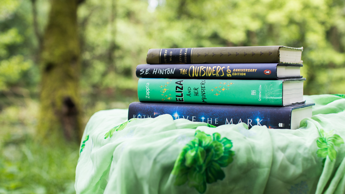 Four books lying on a cloth.