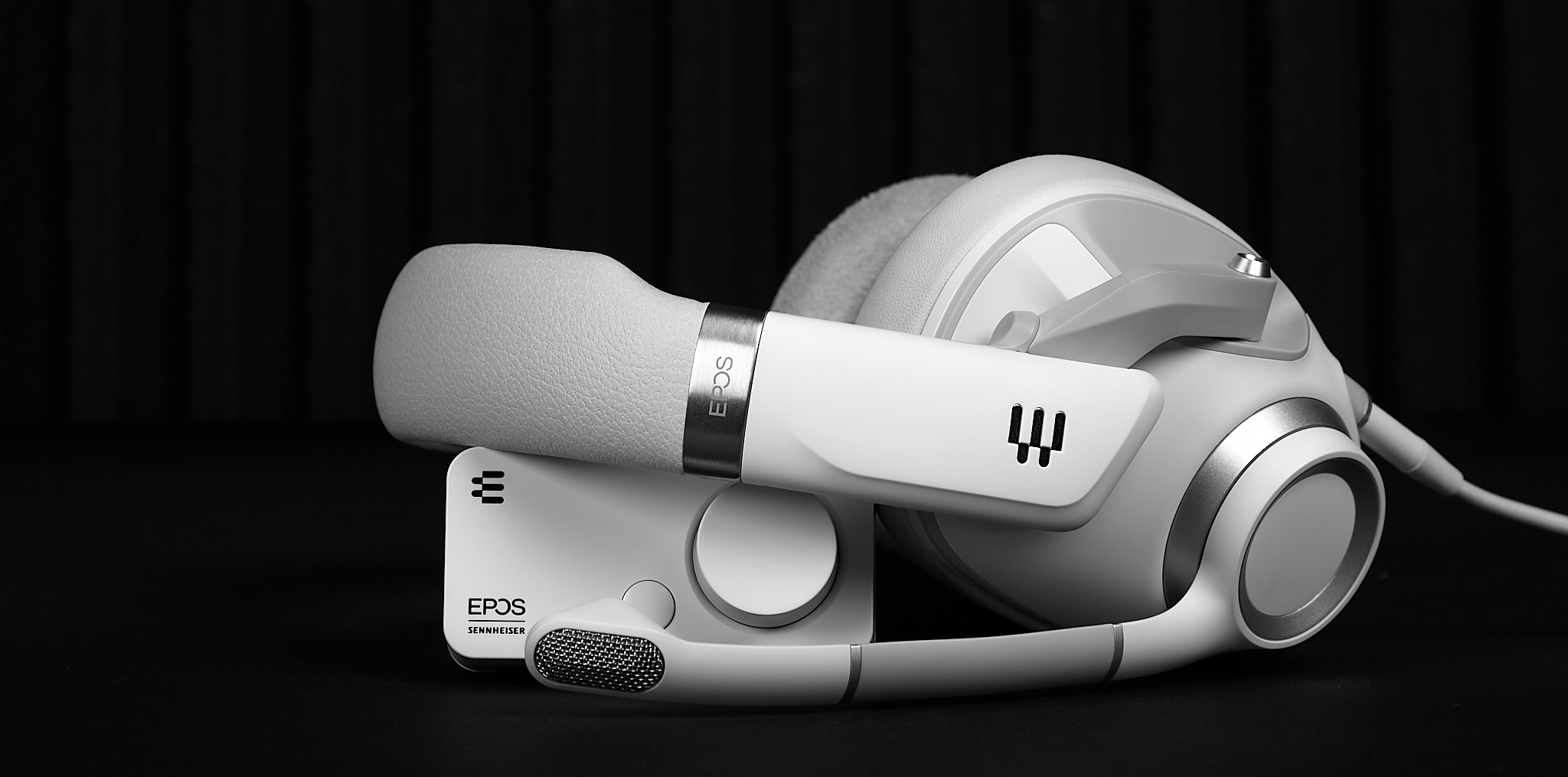 A white headset lying on a white external sound card.