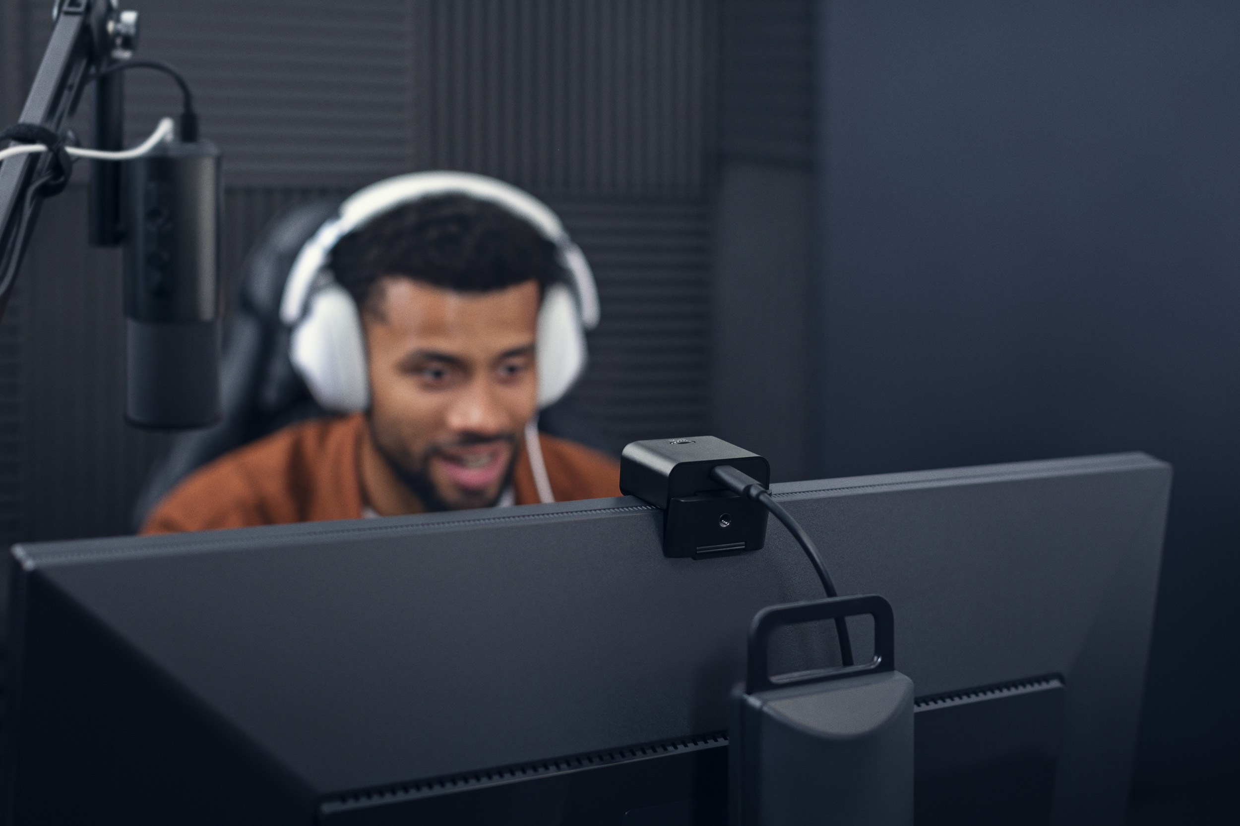A man looking at a computer monitor with the S6 webcam on top.