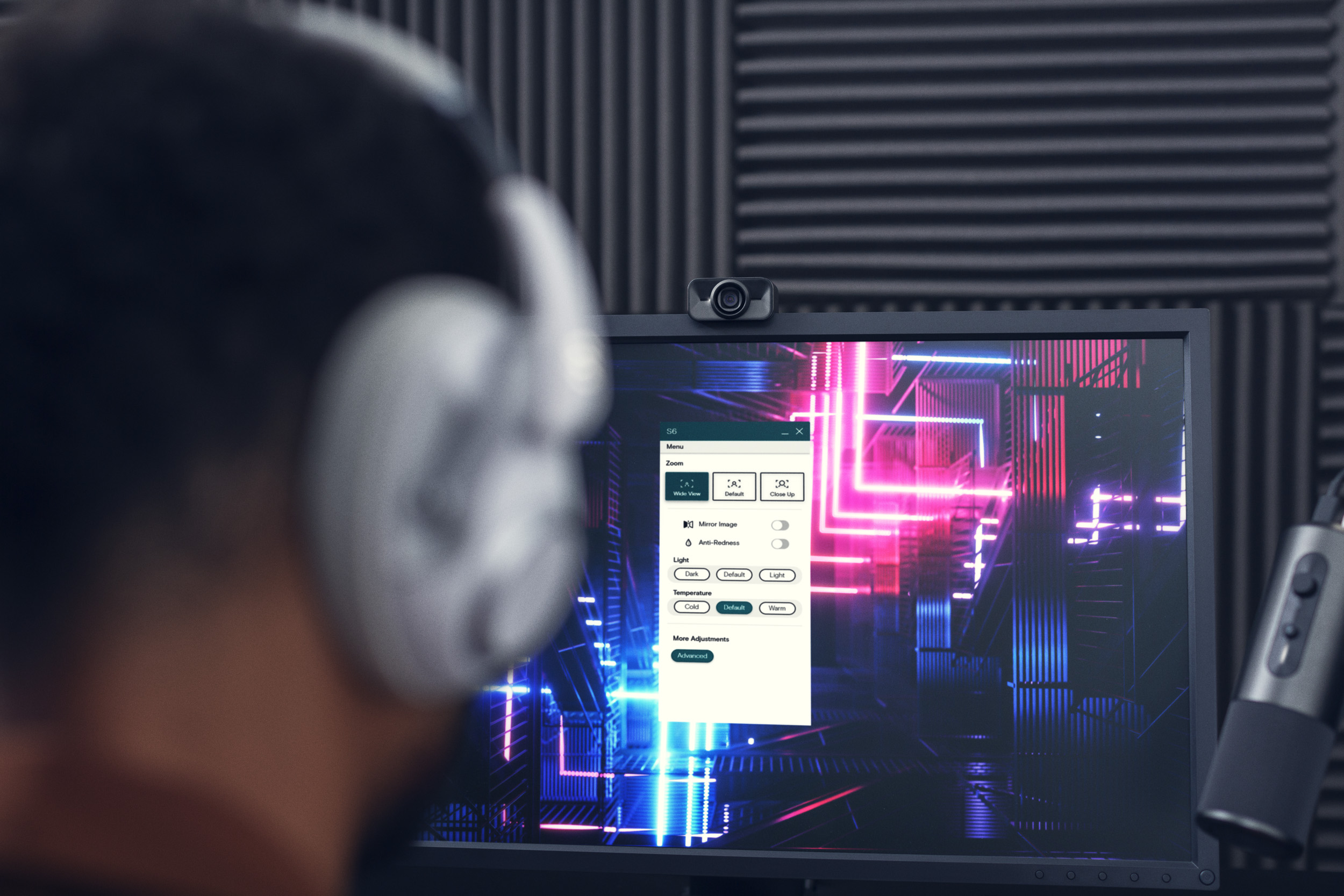 A man looking at a computer monitor with the S6 webcam on top.