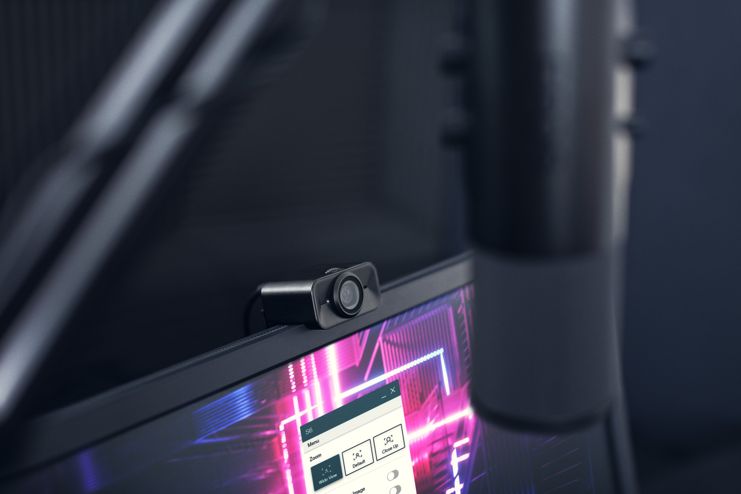 The S6 webcam on top of a computer monitor with a microphone in front of it.