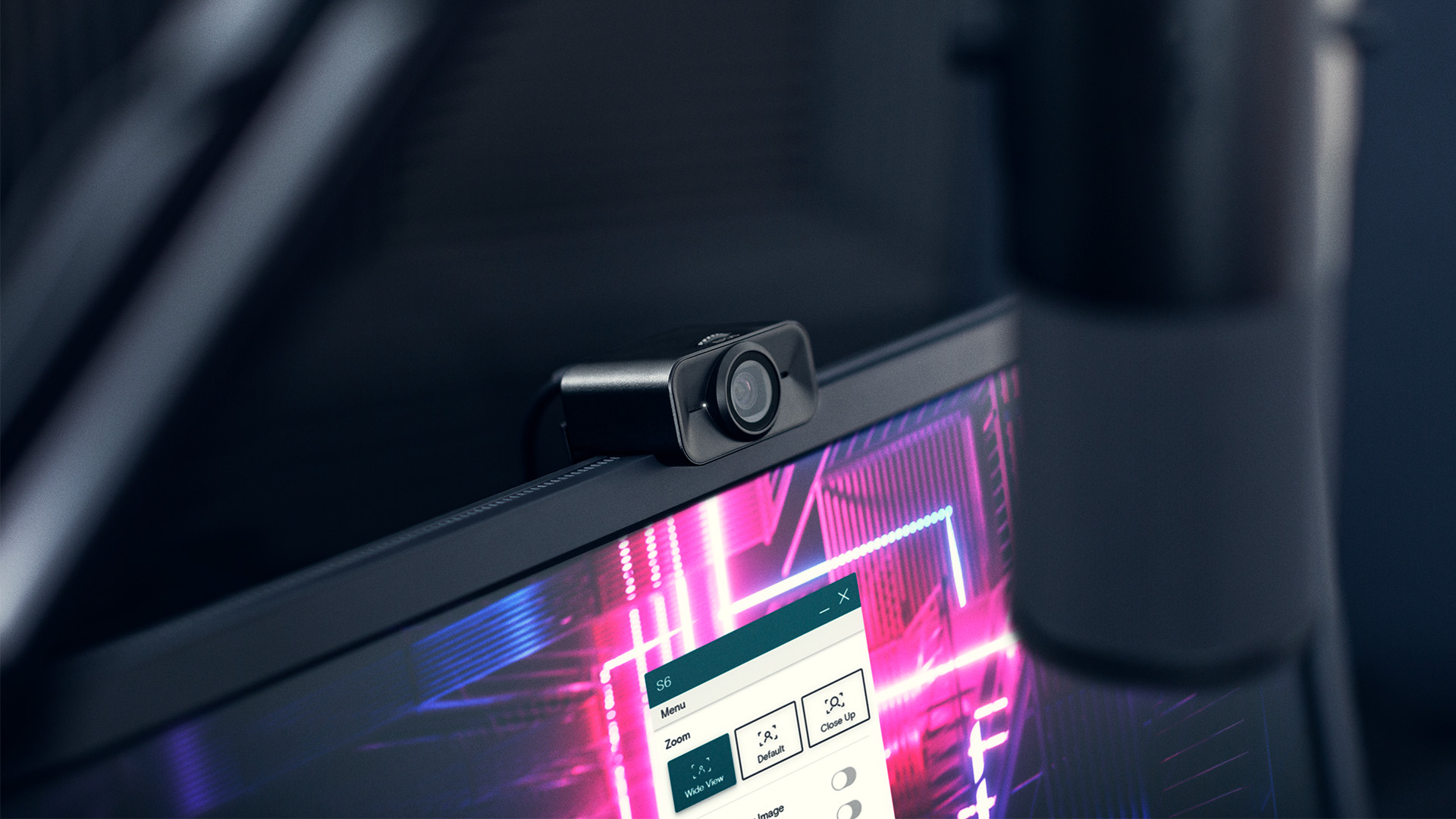 The S6 webcam on top of a computer monitor with a microphone in front of it.