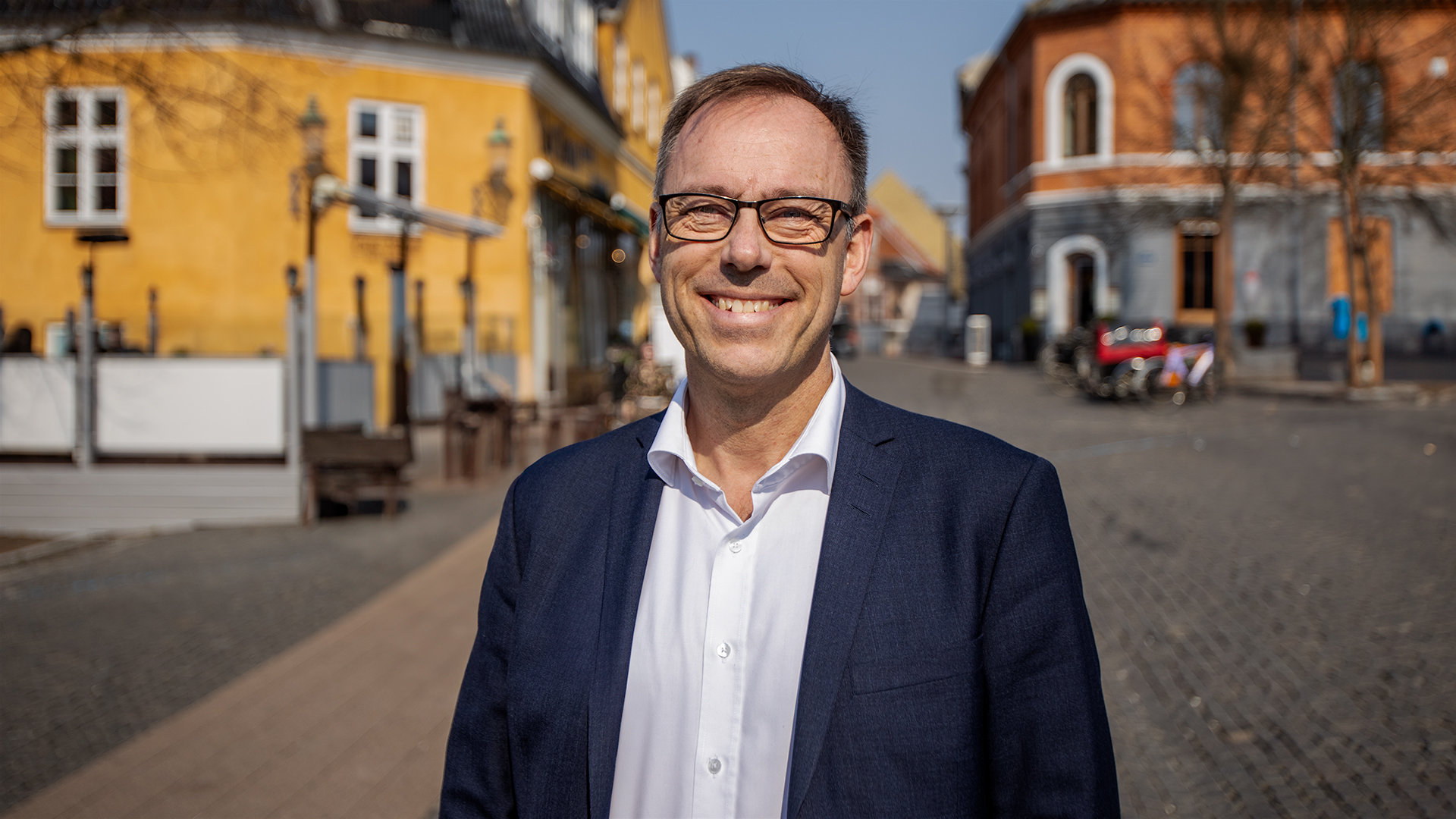 A man is standing and smiling.