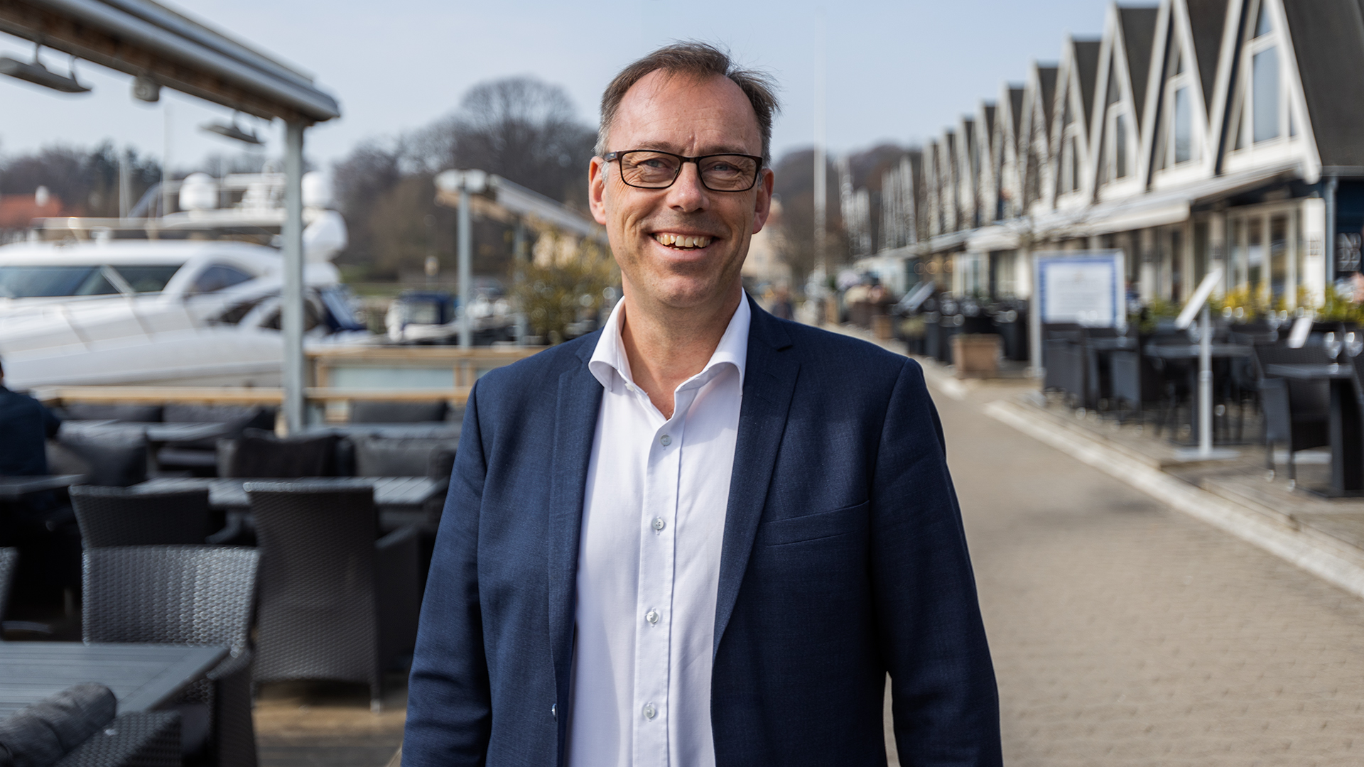 A man is standing and smiling.