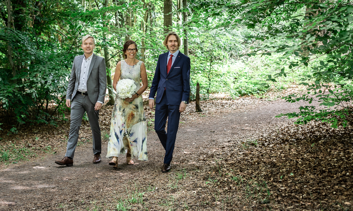 The bride and two men walking in nature.