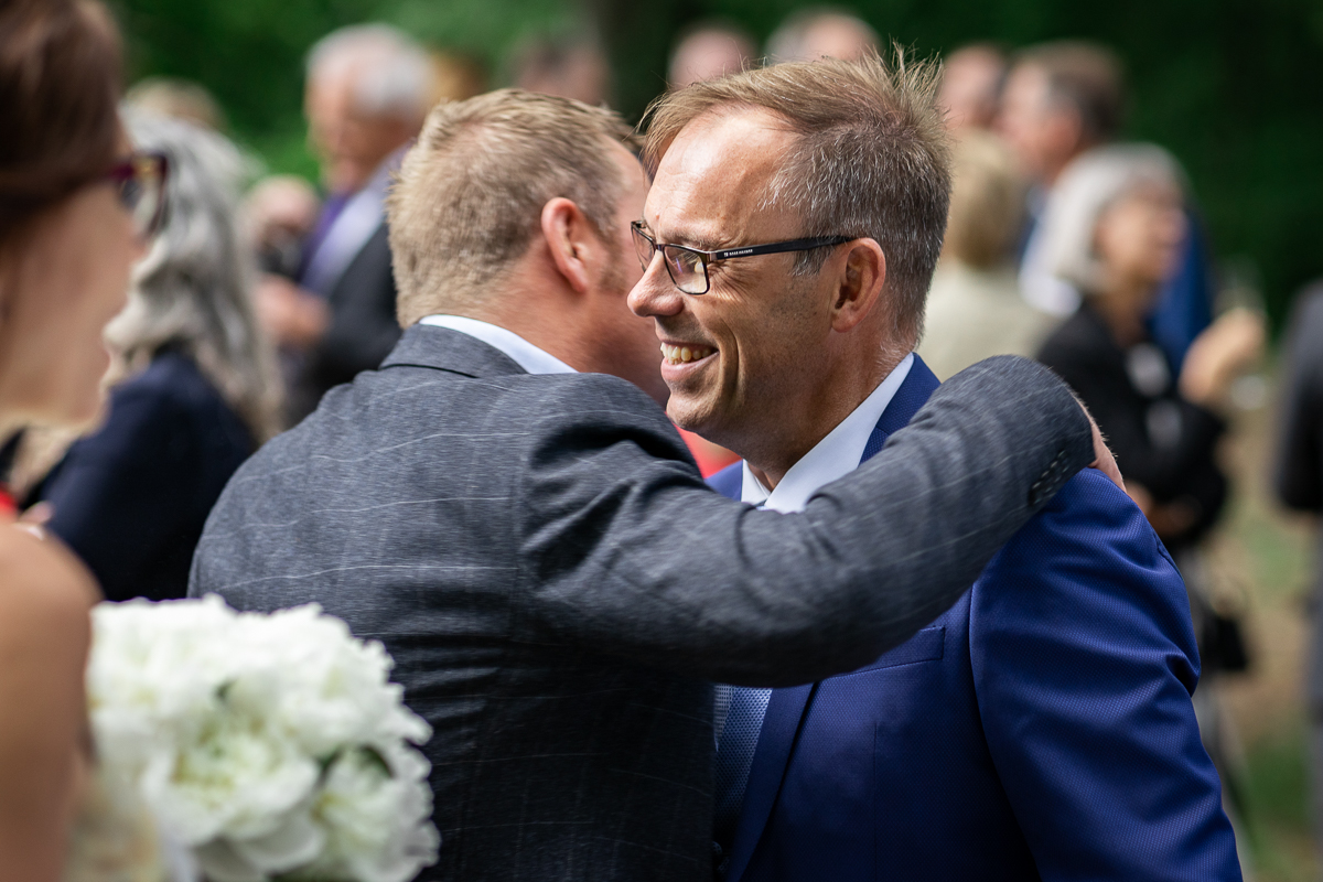 The groom hugging another person.