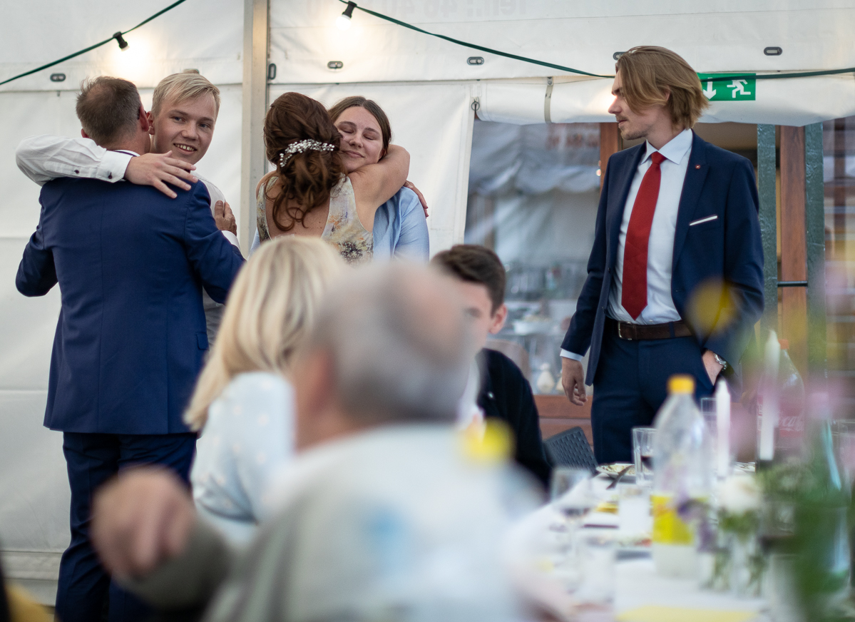 The bride and groom hugging their family.