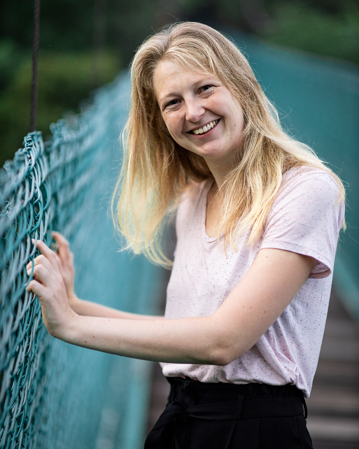 A woman smiling on a bridge