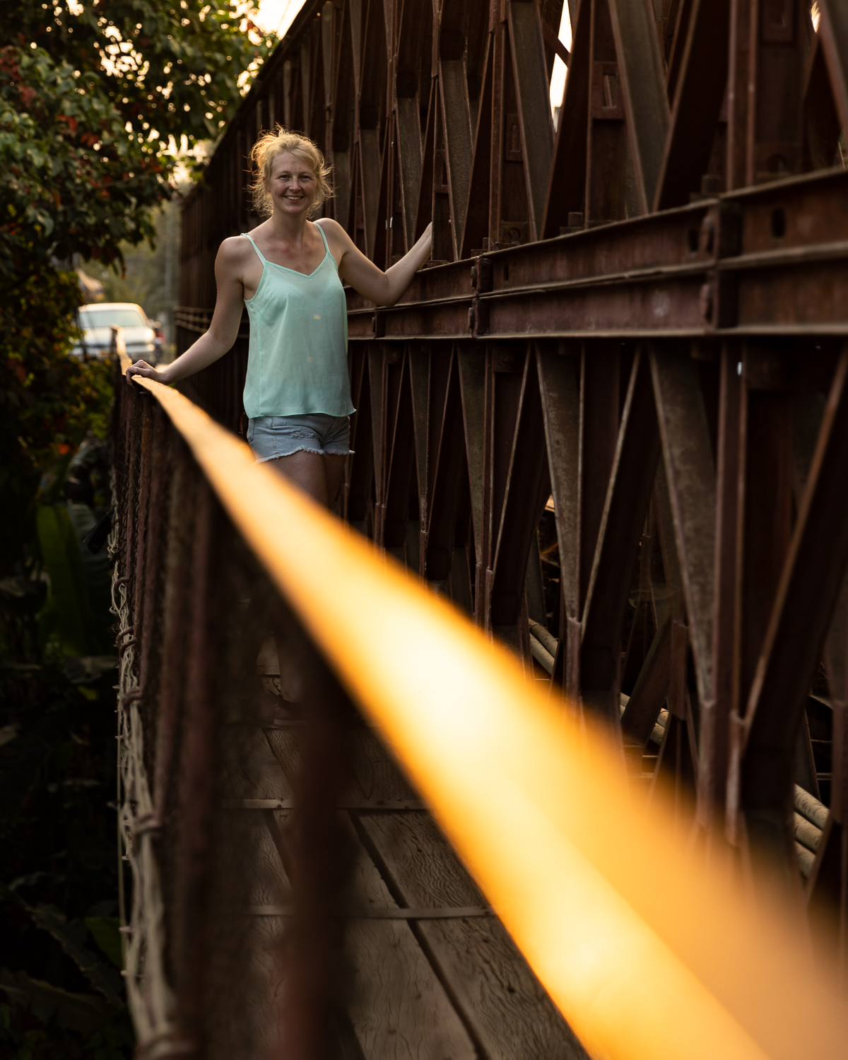 A woman smiling on a bridge.